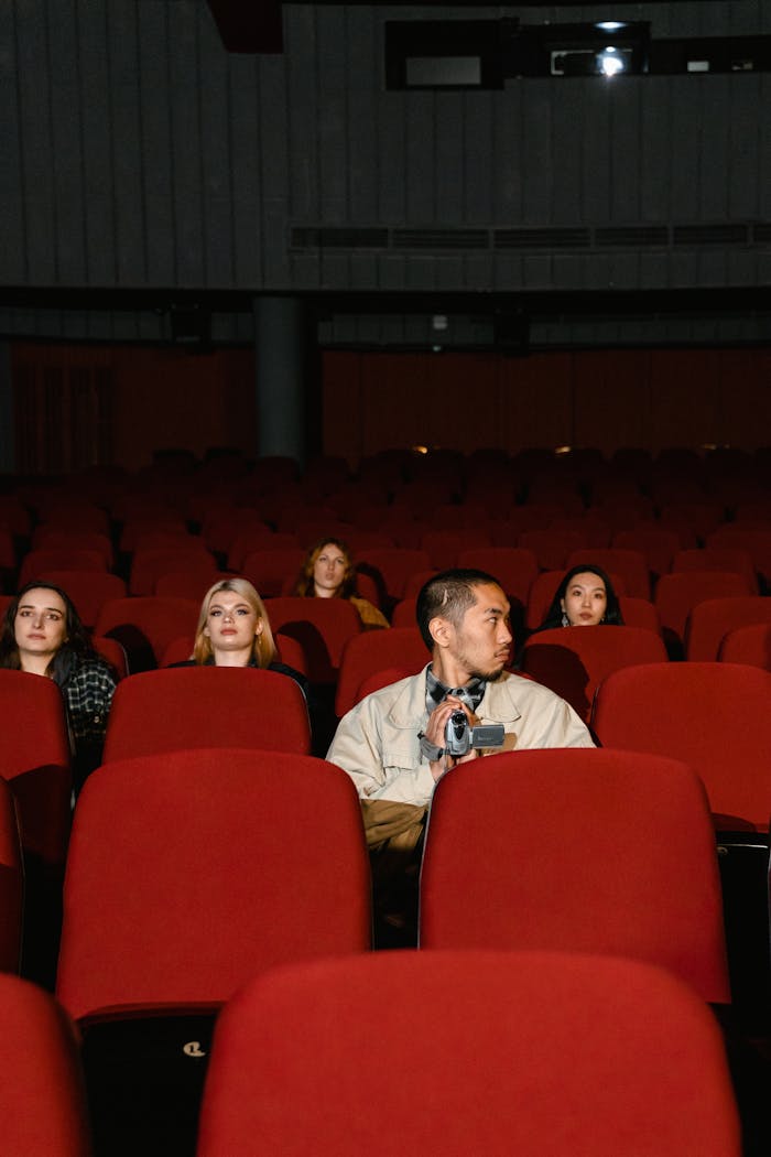 A diverse group of people sitting in a theater watching a film.