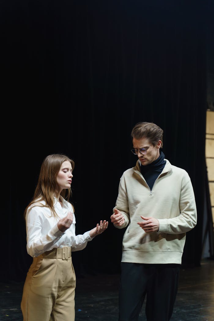 Actors rehearsing a dramatic scene on a theater stage, capturing emotion and artistry.